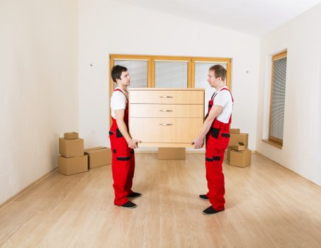 Loading boxes and furniture into a removal truck in Acton